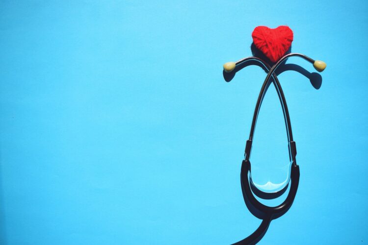 Medical stethoscope head and red heart