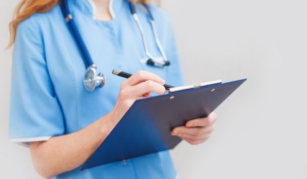Female doctor writes notes on the clipboard